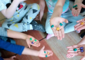 dzieci pokazują kulki plasteliny połączone patyczkami